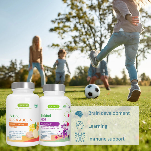 Two supplement bottles labeled 'Be kind Kids & Adults' and 'Be kind Kids' on a grassy field with children playing soccer.