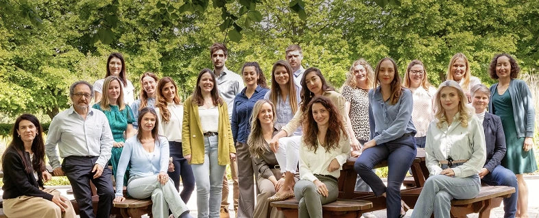 Group of people posing outdoors with trees in the background