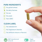 Hand holding a green capsule with purity and approval information on a white background
