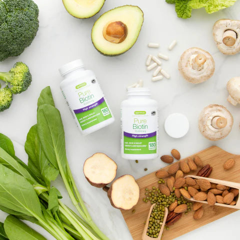Two bottles of Pure Vegan supplements on a white surface with fresh vegetables and nuts.