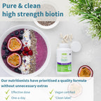 Pure & clean high strength biotin supplement with a bowl of fruit and a plant in the background.