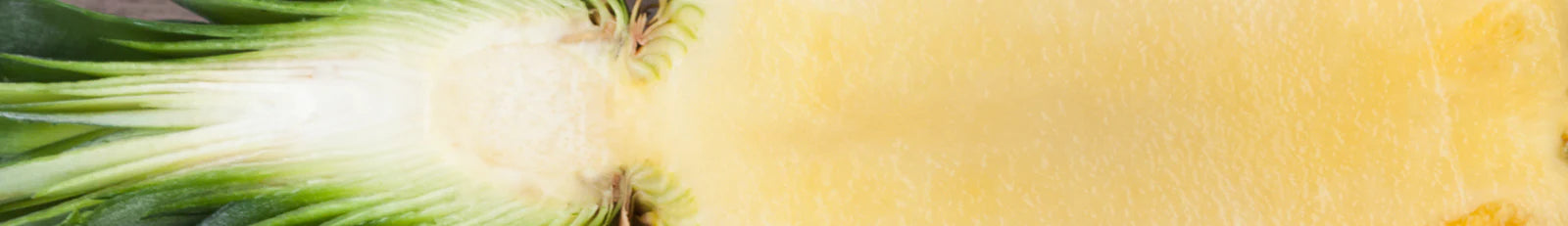 Close-up of a sliced pineapple with green leaves on a white background
