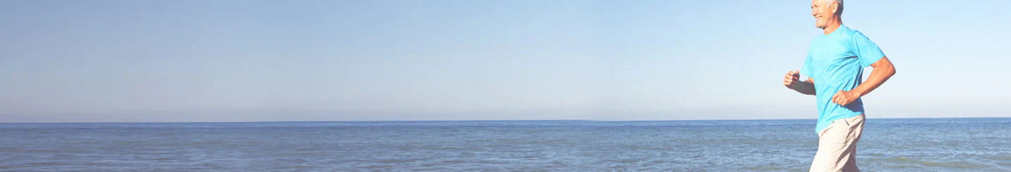 Man running on a beach with clear blue sky
