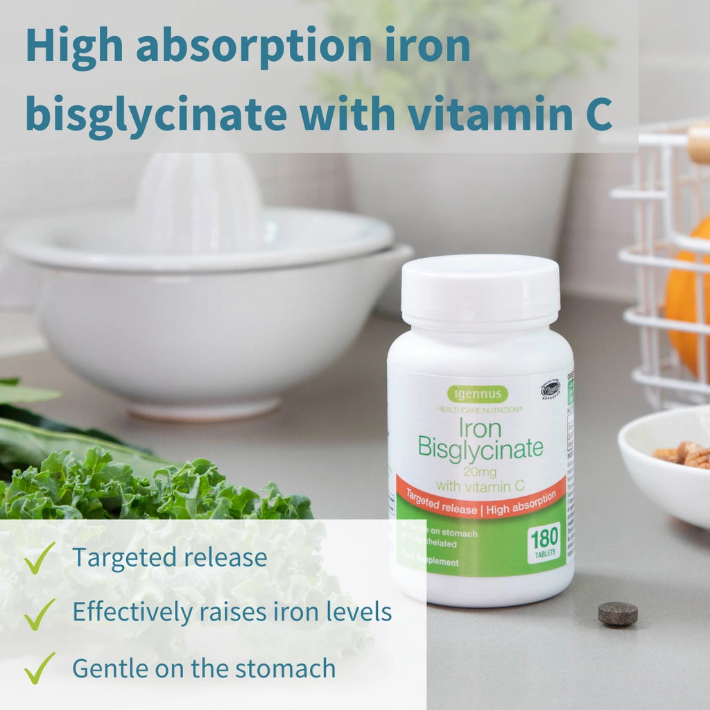 Bottle of Iron Bisglycinate supplement with vitamin C on a kitchen counter, surrounded by vegetables.