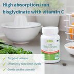 Bottle of Iron Bisglycinate supplement with vitamin C on a kitchen counter, surrounded by vegetables.