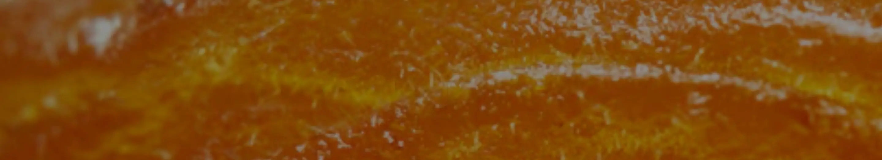 Close-up of a textured orange surface with white specks