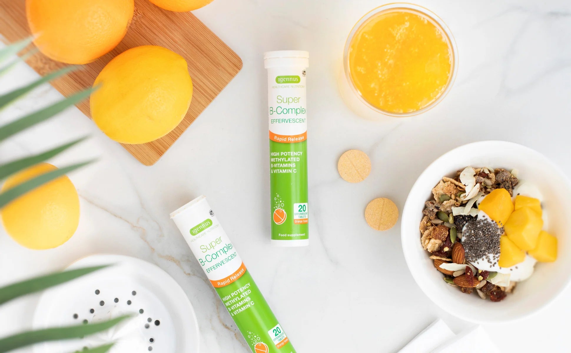 Supplement sticks with oranges, a smoothie, and granola on a white background