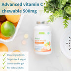 Vitamin C chewable supplement bottle with fruits and a plant on a light surface