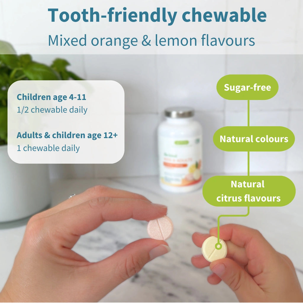 Two hands holding chewable tablets with product details on a blurred background