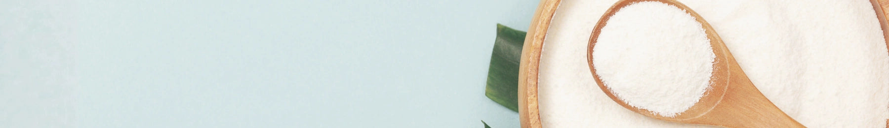 Coconut with a wooden spoon on a light blue background