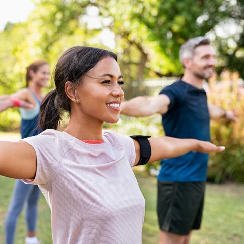 Woman exercising outdoors with friends in a park