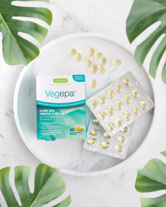 Vegepa supplement packaging on a marble surface with green leaves in the background