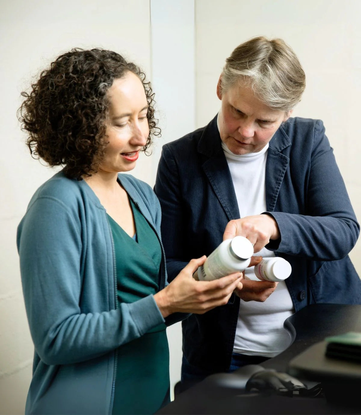 Two women examining a product together in an indoor setting.