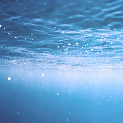 Underwater scene with light rays penetrating the water surface