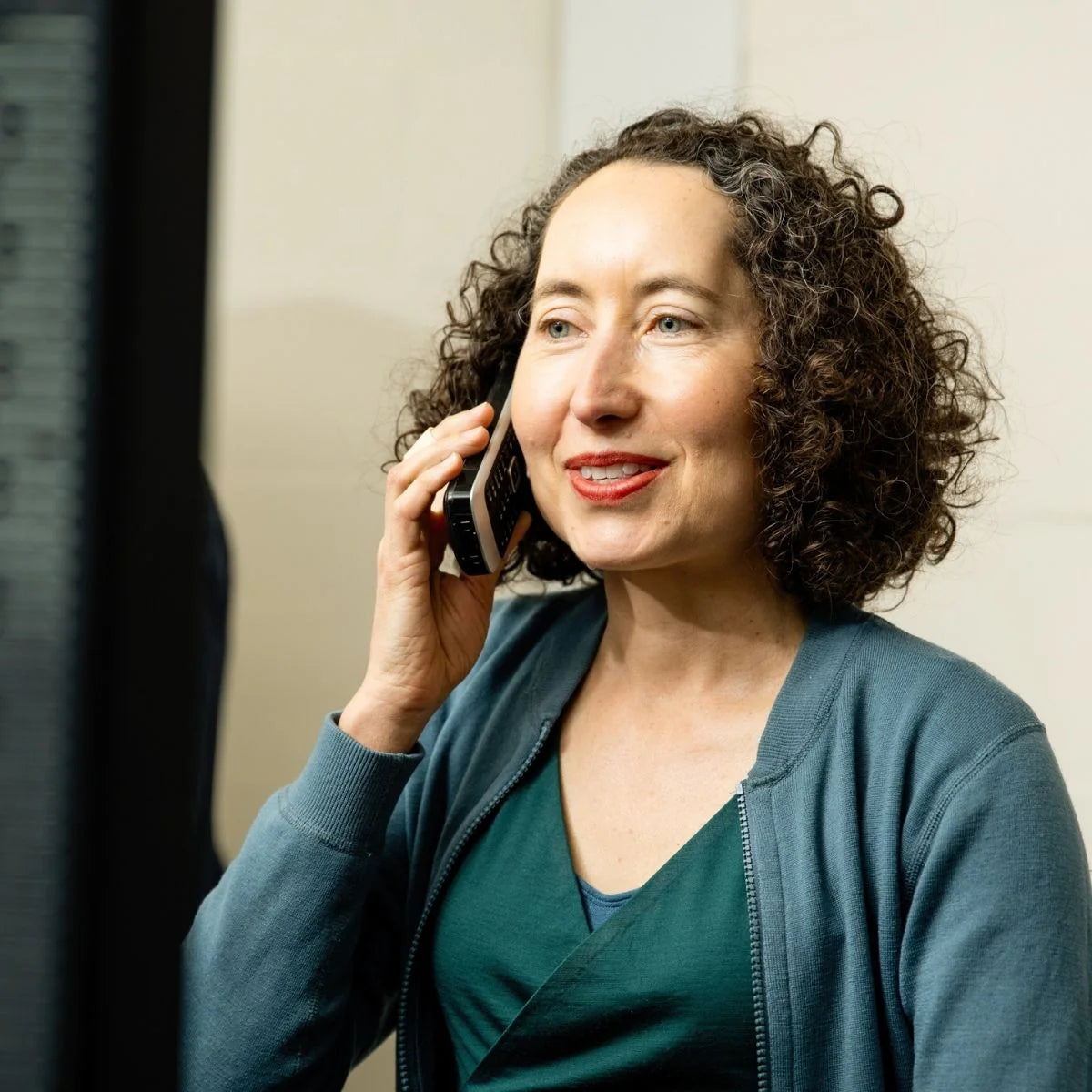 Woman talking on a phone with a neutral background