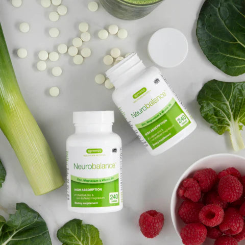 Neurobalance supplement bottles with green leaves, raspberries, and a smoothie on a white background
