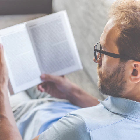 Man reading a book on a couch