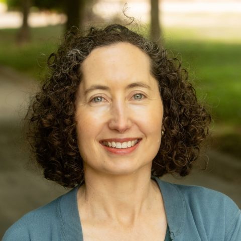 Woman with curly hair smiling outdoors