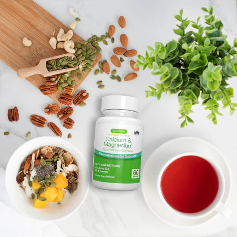 Supplement bottle labeled 'Calcium & Magnesium' on a table with nuts, seeds, and tea.