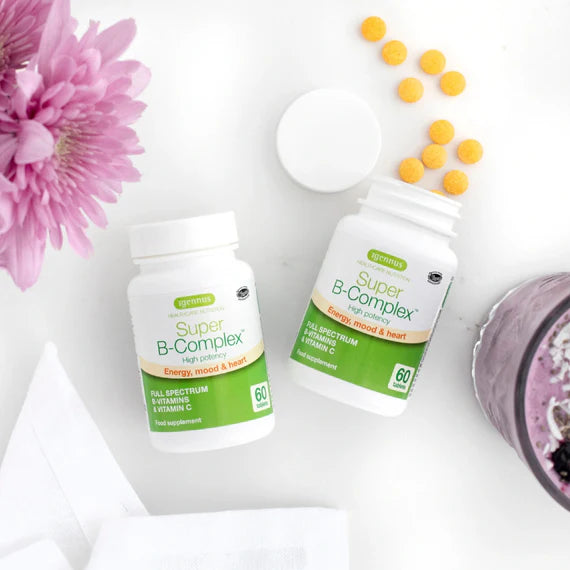 Two bottles of Super B-Complex vitamins with scattered pills on a white surface with pink flowers.