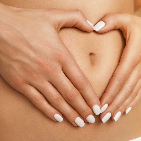 Close-up of hands forming a heart shape over a bare stomach.