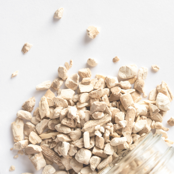 Dry herbs or spices in a glass container on a white background