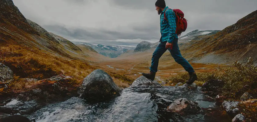 Person hiking through a mountainous landscape with a backpack