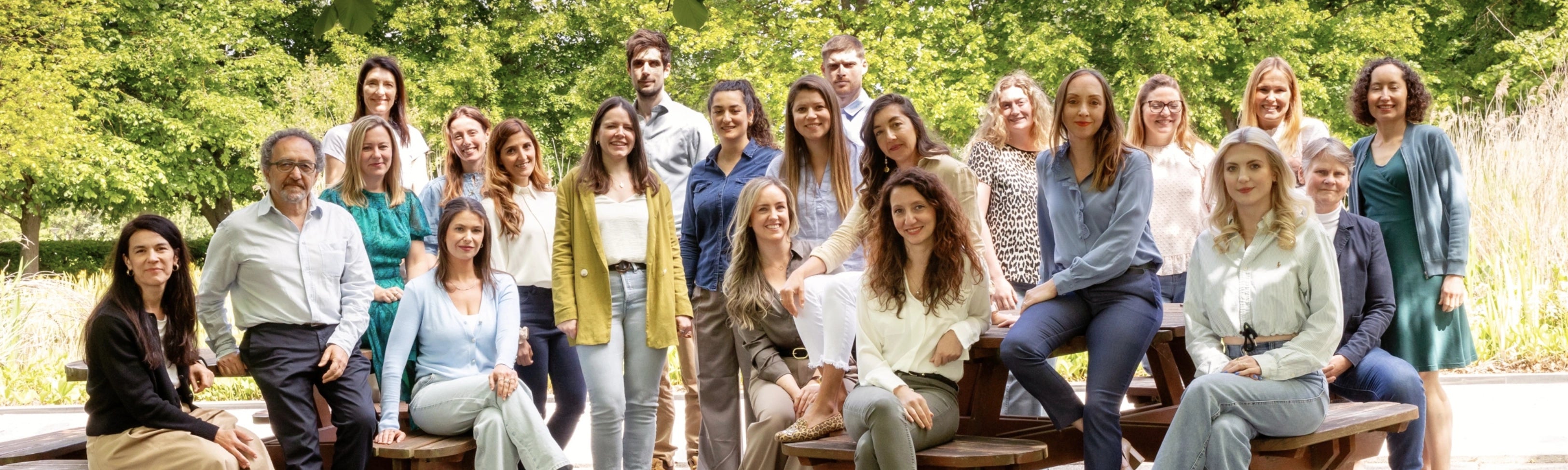 Group of people posing outdoors with trees in the background